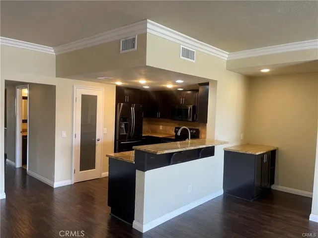 a kitchen with kitchen island stainless steel appliances a sink stove and refrigerator