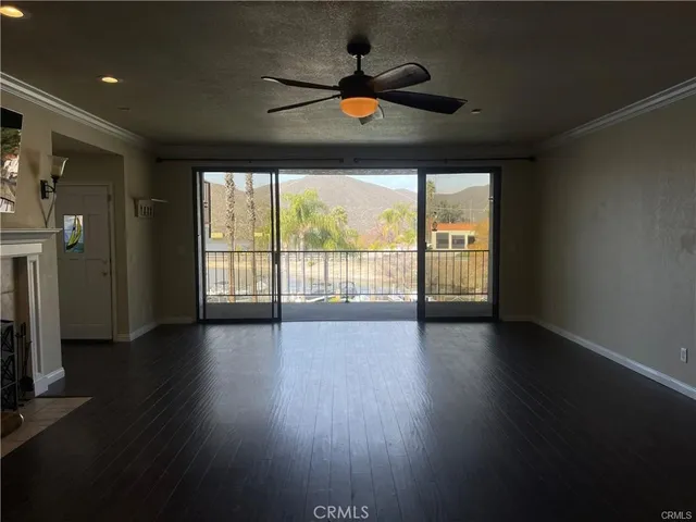 a living room with wooden floor and a fireplace