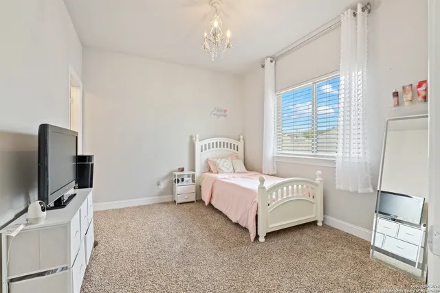 a spacious bedroom with a bed and a flat screen tv