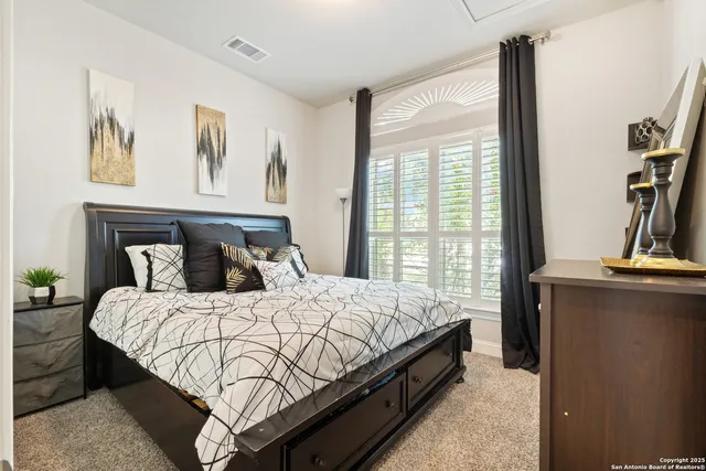 a bedroom with a large bed and a flat tv screen on the dresser