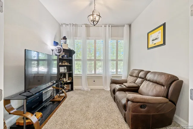 a living room with furniture a flat screen tv and a window