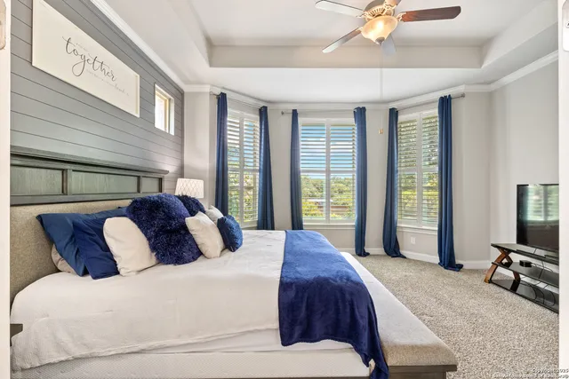 a bedroom with a large bed and a flat tv screen on dresser