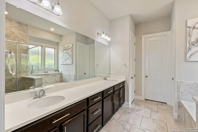 a bathroom with a double vanity sink a mirror and a shower