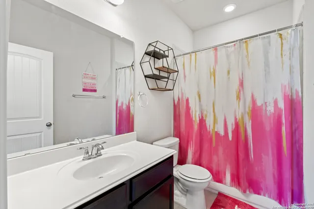 a bathroom with a sink vanity mirror and toilet