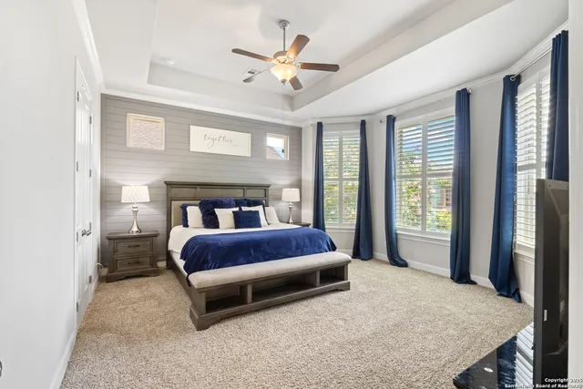 a spacious bedroom with a bed a window and a chandelier
