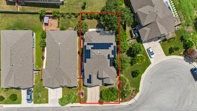 an aerial view of a house with yard and swimming pool