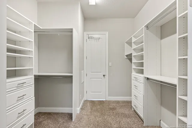 a view of walk in closet with empty racks