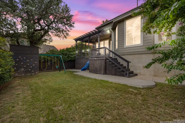 a view of a house with backyard and tree