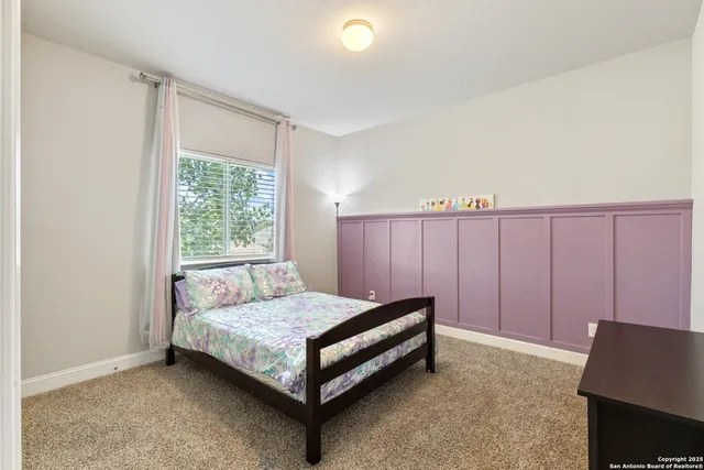 a bed sitting in a spacious bedroom next to a window