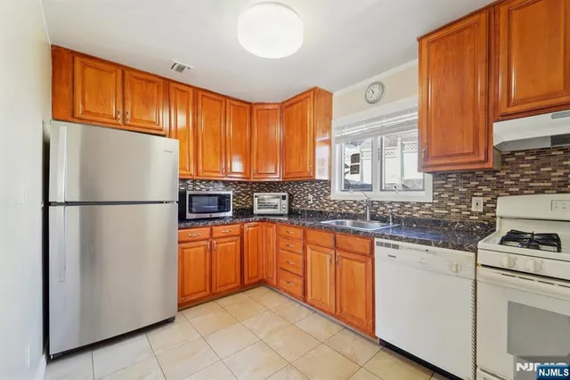 a kitchen with stainless steel appliances granite countertop a refrigerator sink and cabinets