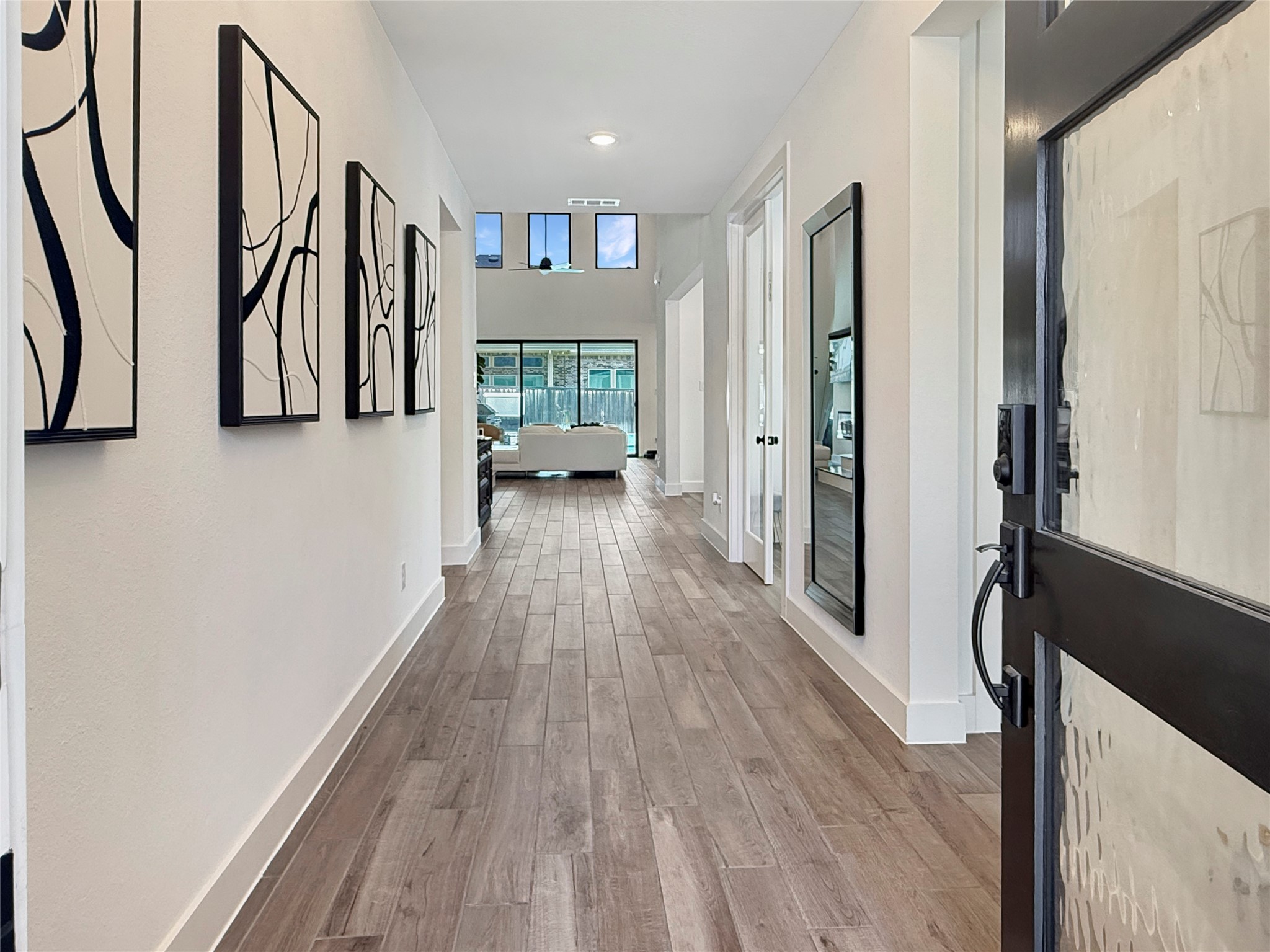 26918 Swanborough Road Spring, TX 77389 - Photo 5 of 50 Step through the iron and glass front door into a light-filled entry hall, where high ceilings and clerestory windows draw the eye straight through to the living room beyond.