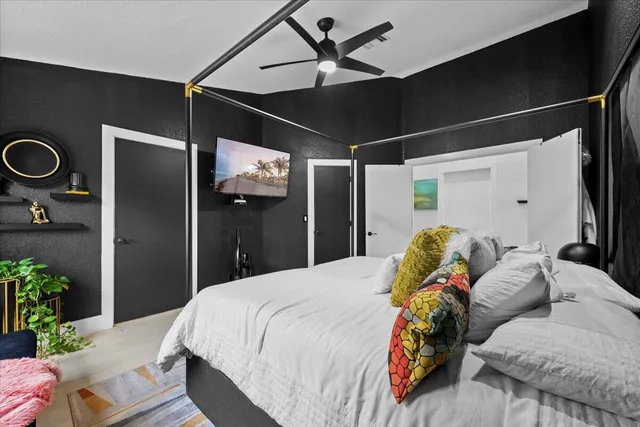 a bed room with a bed and a ceiling fan