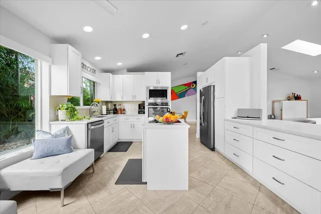 a kitchen with white cabinets and stainless steel appliances