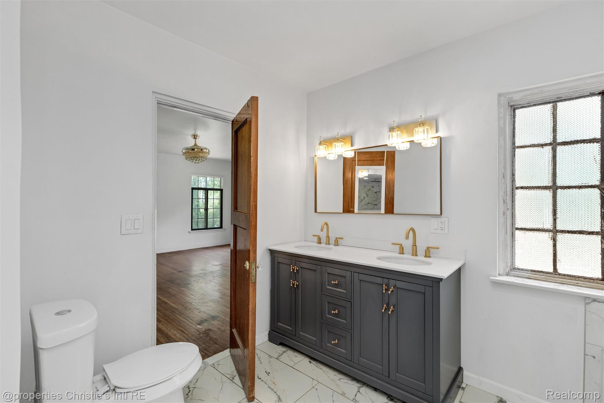 3205 Sherbourne Road Detroit, MI 48221 - Photo 57 of 81 Bathroom featuring a double vanity with a dark gray cabinet, white countertop, and gold-finish hardware