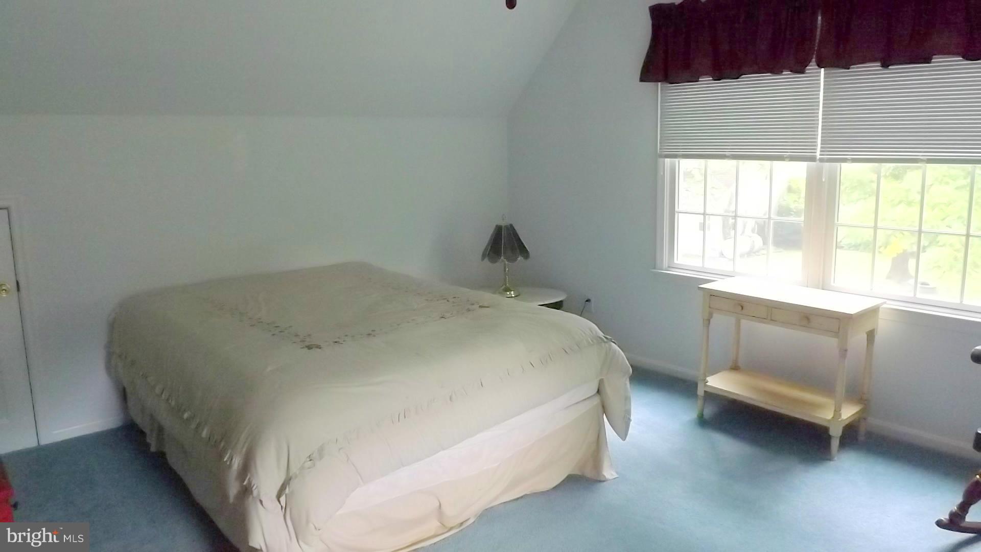 103 Douglas Ln Street St. Michaels, MD 21663 - Photo 19 of 28 a bed sitting in a bedroom next to a window