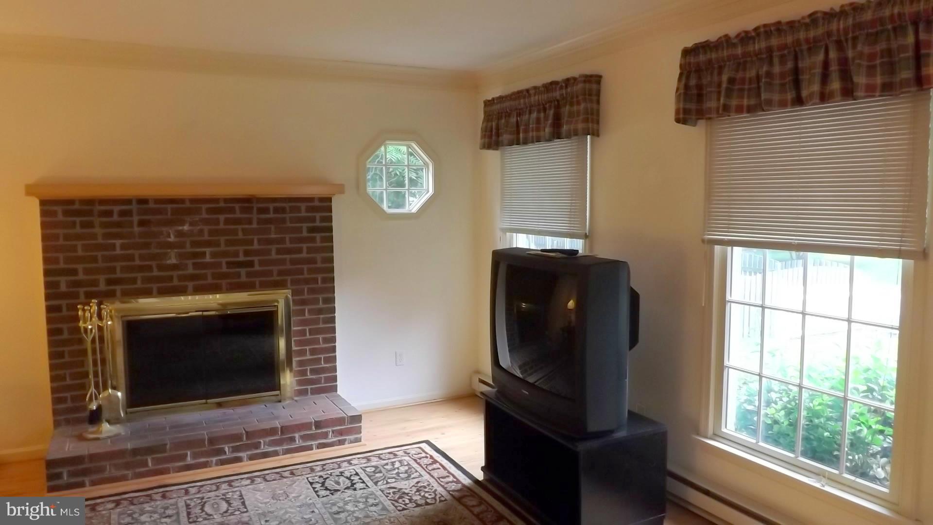 103 Douglas Ln Street St. Michaels, MD 21663 - Photo 10 of 28 a living room with furniture a large window and a fireplace