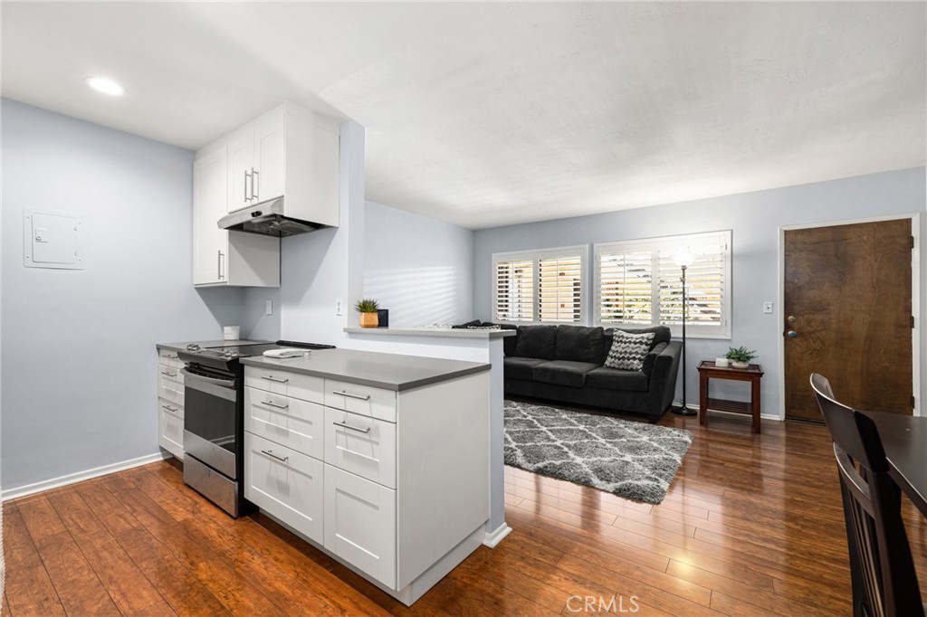 360 Gladys Avenue, Unit 2 Long Beach, CA 90814 - Photo 8 of 22 a kitchen with stainless steel appliances granite countertop a stove a sink a refrigerator and white cabinets with wooden floor