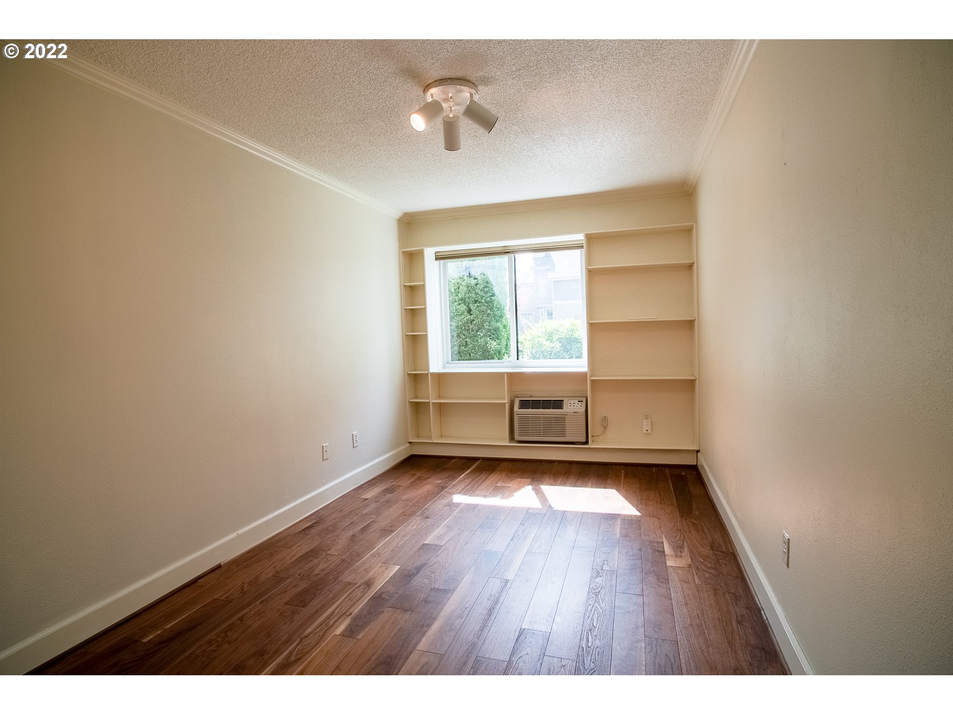 1727 Northeast Multnomah Street, Unit 2 Portland, OR 97232 - Photo 7 of 10 a view of an empty room with a window and wooden floor