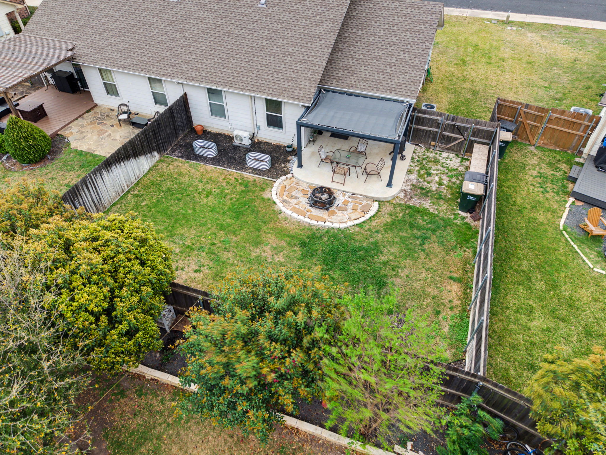 a view of backyard with table and chairs and potted plants