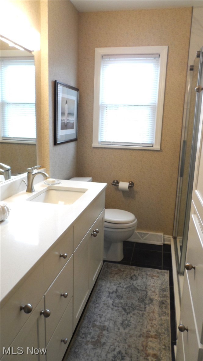 2542 Carson Road Fairlawn, OH 44333 - Photo 9 of 28 Bathroom with toilet, vanity, tile patterned floors, and a shower with door