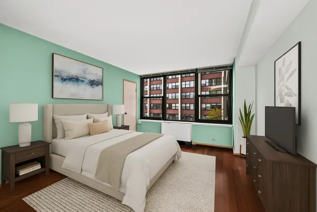 a bedroom with a large window and a flat screen tv