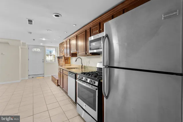a kitchen with stainless steel appliances granite countertop a refrigerator and a stove