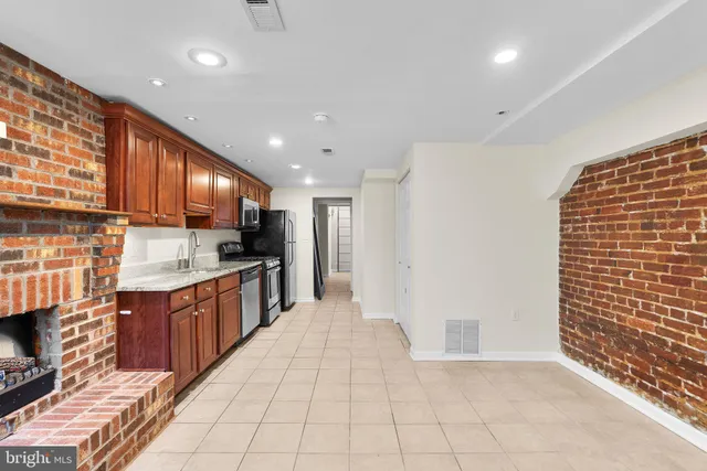 a large kitchen with stainless steel appliances a refrigerator and a stove top oven