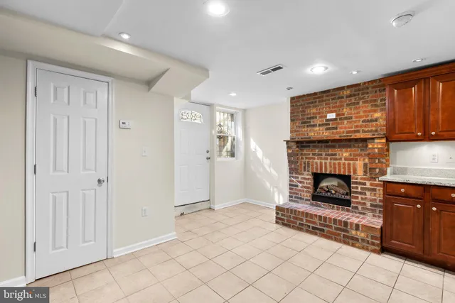 a view of a livingroom with a fireplace cabinet and window