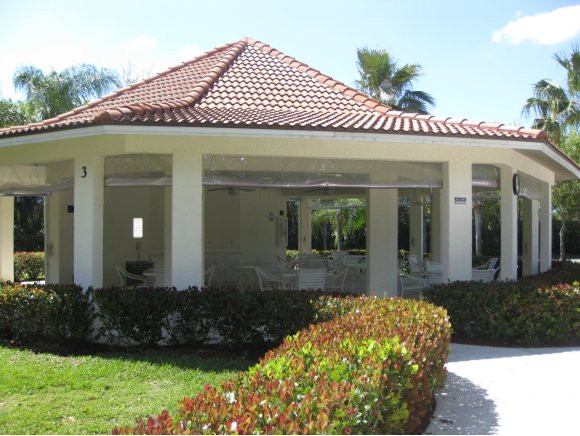 409 Gabriel Circle, Unit 7 Naples, FL 34104 - Photo 16 of 18 a front view of a house with a yard