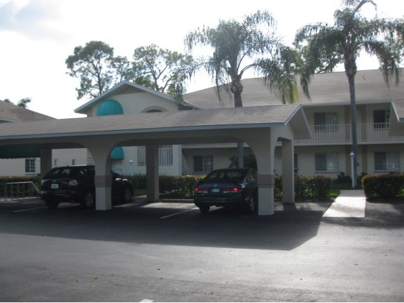 409 Gabriel Circle, Unit 7 Naples, FL 34104 - Photo 3 of 18 a car parked in front of a building