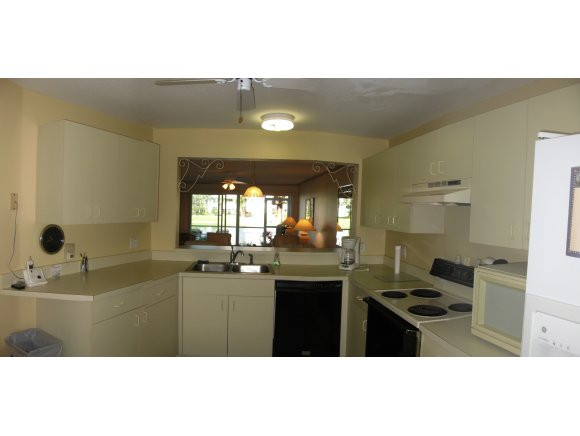 409 Gabriel Circle, Unit 7 Naples, FL 34104 - Photo 4 of 18 a kitchen with granite countertop a sink cabinets and wooden floor