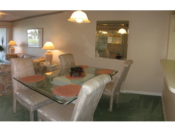409 Gabriel Circle, Unit 7 Naples, FL 34104 - Photo 6 of 18 a view of a dining room with furniture and wooden floor