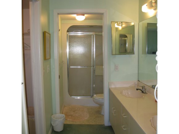 409 Gabriel Circle, Unit 7 Naples, FL 34104 - Photo 9 of 18 a bathroom with a tub shower sink and mirror