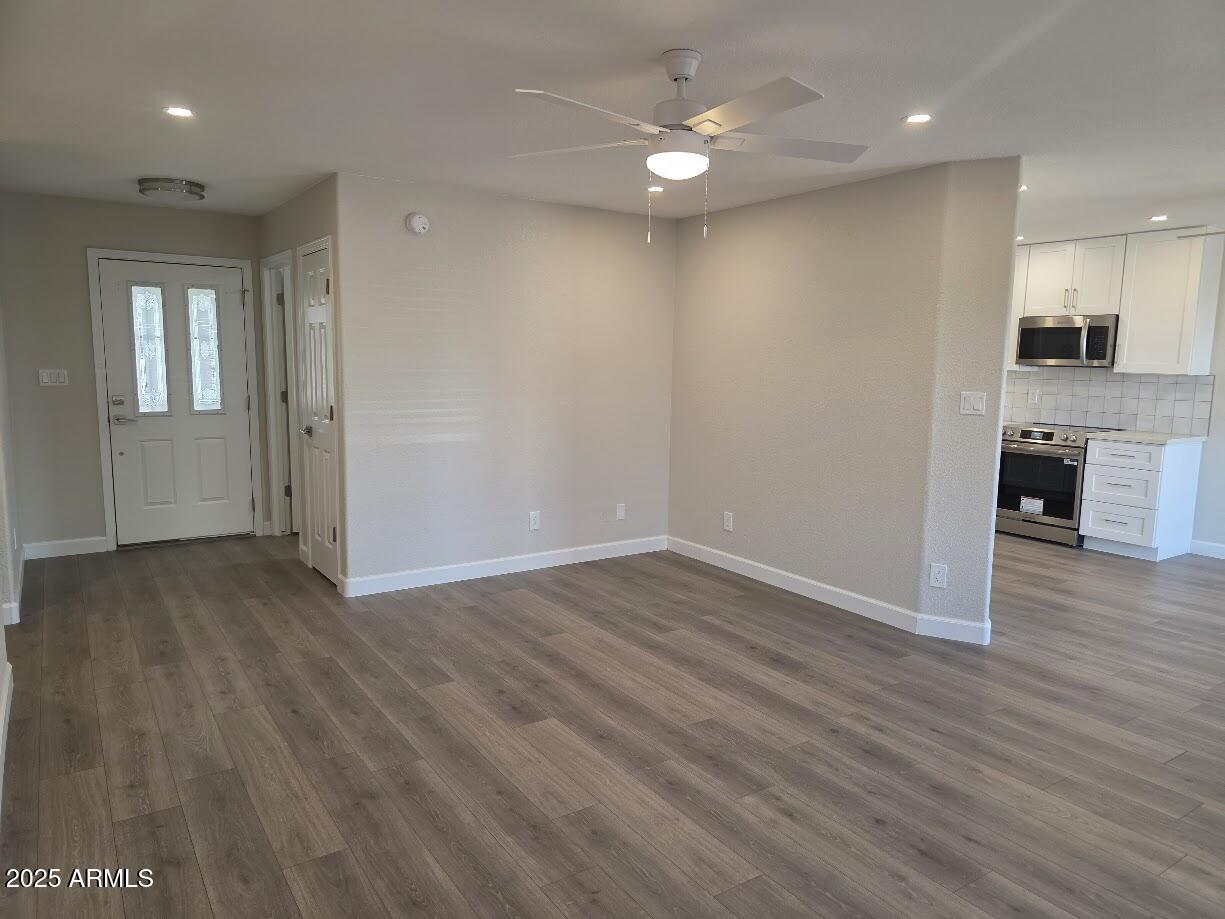 142 West 7th Street Eagar, AZ 85925 - Photo 7 of 25 an empty room with wooden floor cabinet and windows