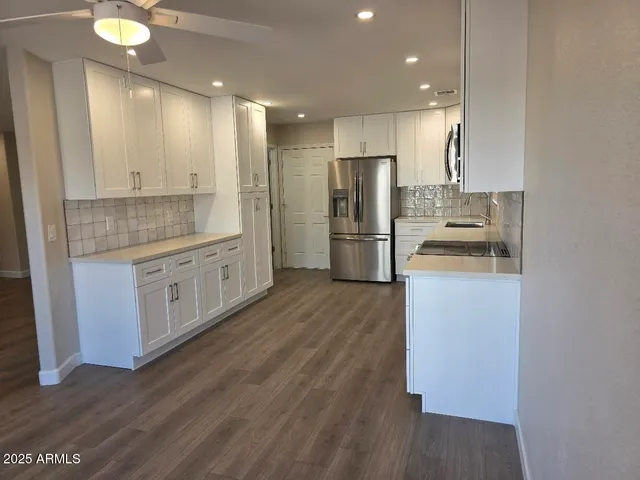 a kitchen with a refrigerator a sink and a stove top oven