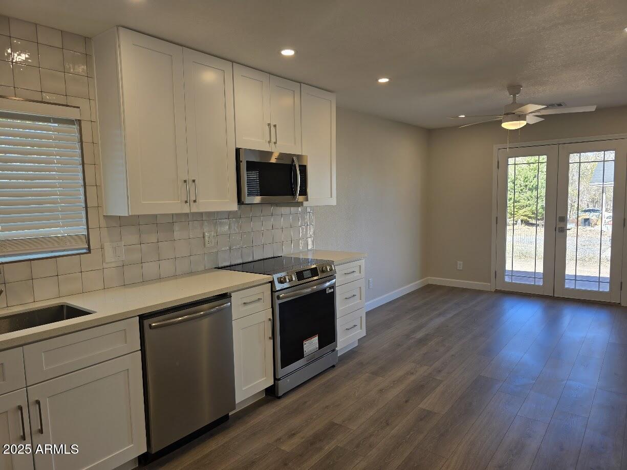 142 West 7th Street Eagar, AZ 85925 - Photo 10 of 25 a kitchen with stainless steel appliances granite countertop a sink a stove a microwave a refrigerator a window and cabinets