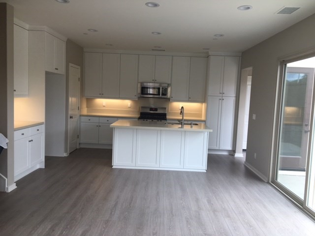 a kitchen with granite countertop white cabinets and stainless steel appliances