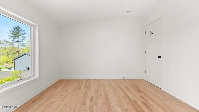 a view of a room with wooden floor and a window