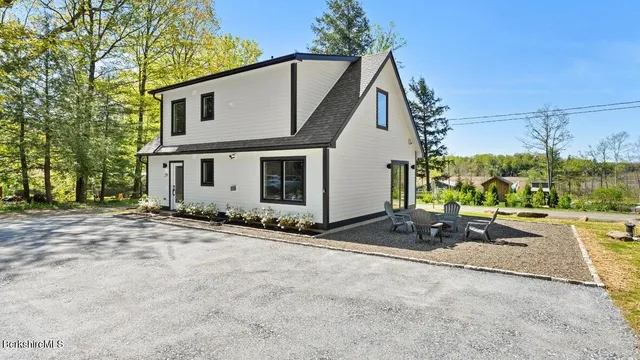 a view of a house with backyard and road
