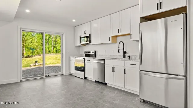 a kitchen with white cabinets and white stainless steel appliances