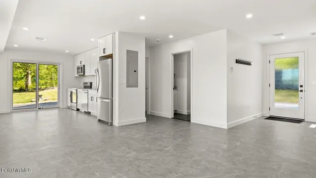 a view of an empty room with a fireplace and a window