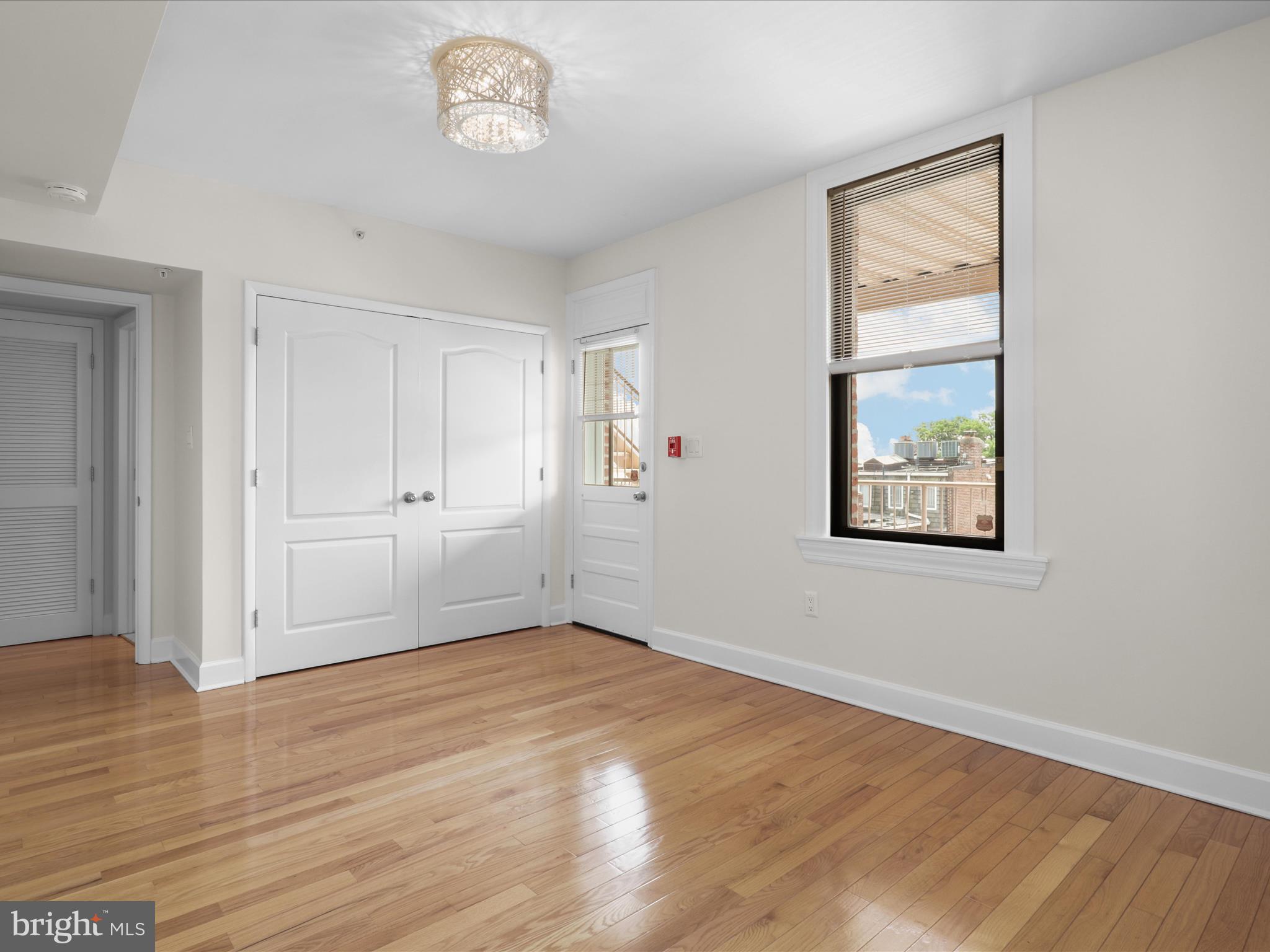 1858 California Street Northwest, Unit 33 Washington, DC 20009 - Photo 20 of 32 a view of an empty room with wooden floor and a window