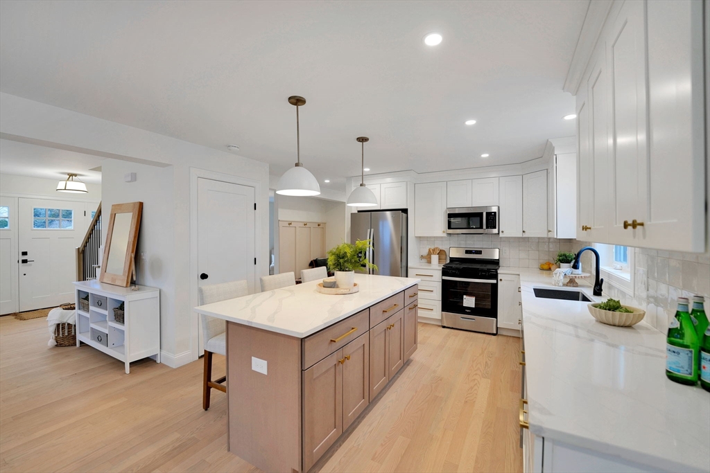 5 Rita's Way Fairhaven, MA 02719 - Photo 11 of 30 a large white kitchen with a stove a sink a refrigerator and chairs