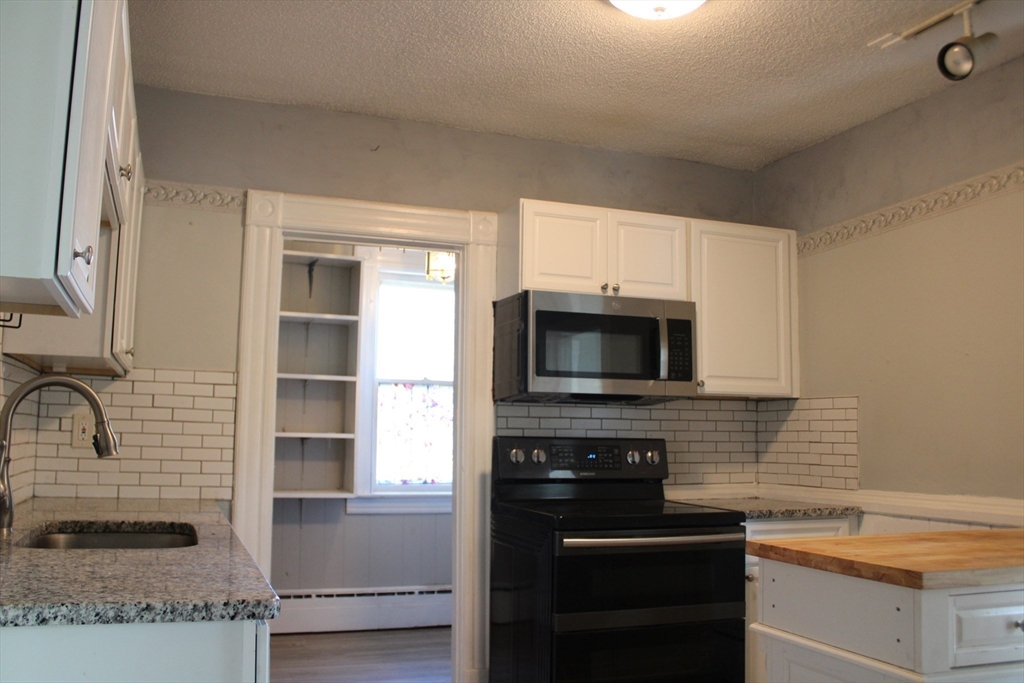 7 State Road Whately, MA 01373 - Photo 11 of 31 a kitchen with kitchen island granite countertop a stove microwave and sink