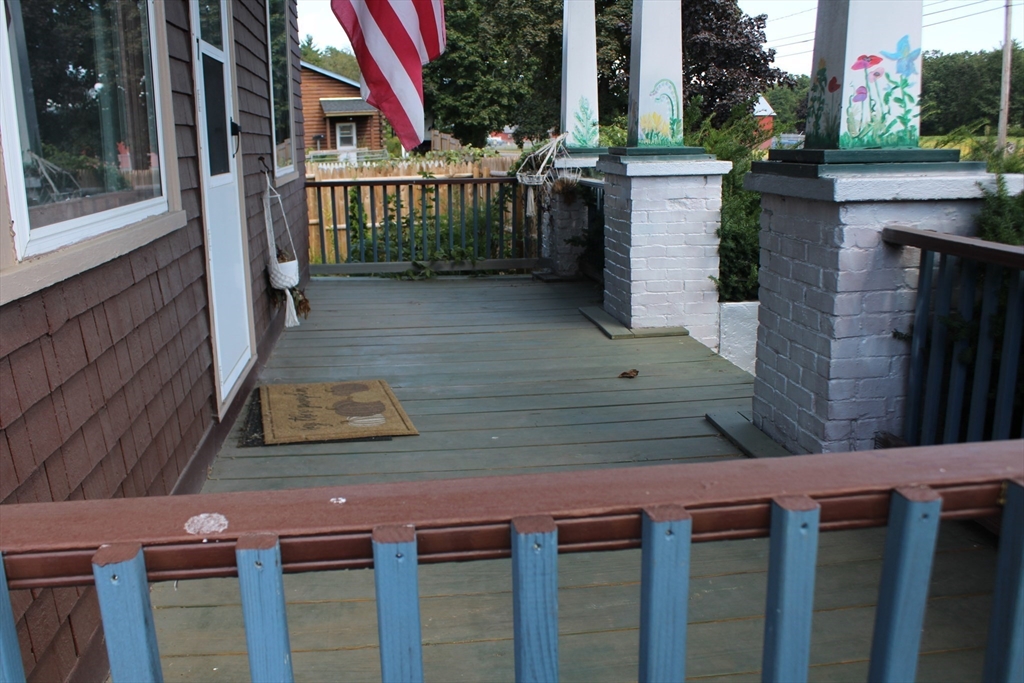 7 State Road Whately, MA 01373 - Photo 4 of 31 a view of a brick house with a small yard and large tree and wooden fence