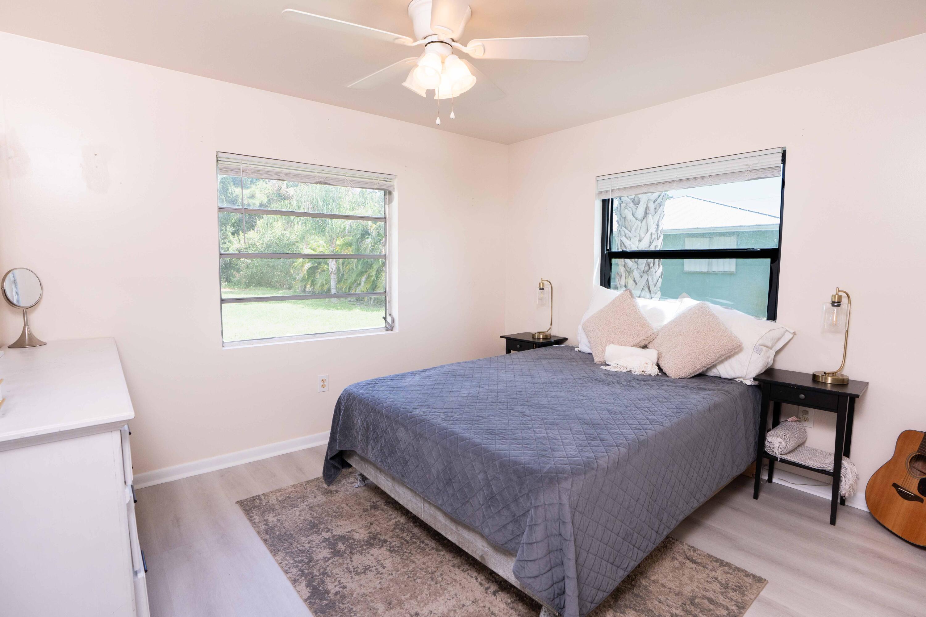 1849 Northwest Pine Tree Way Stuart, FL 34994 - Photo 11 of 29 a bedroom with a bed and a window