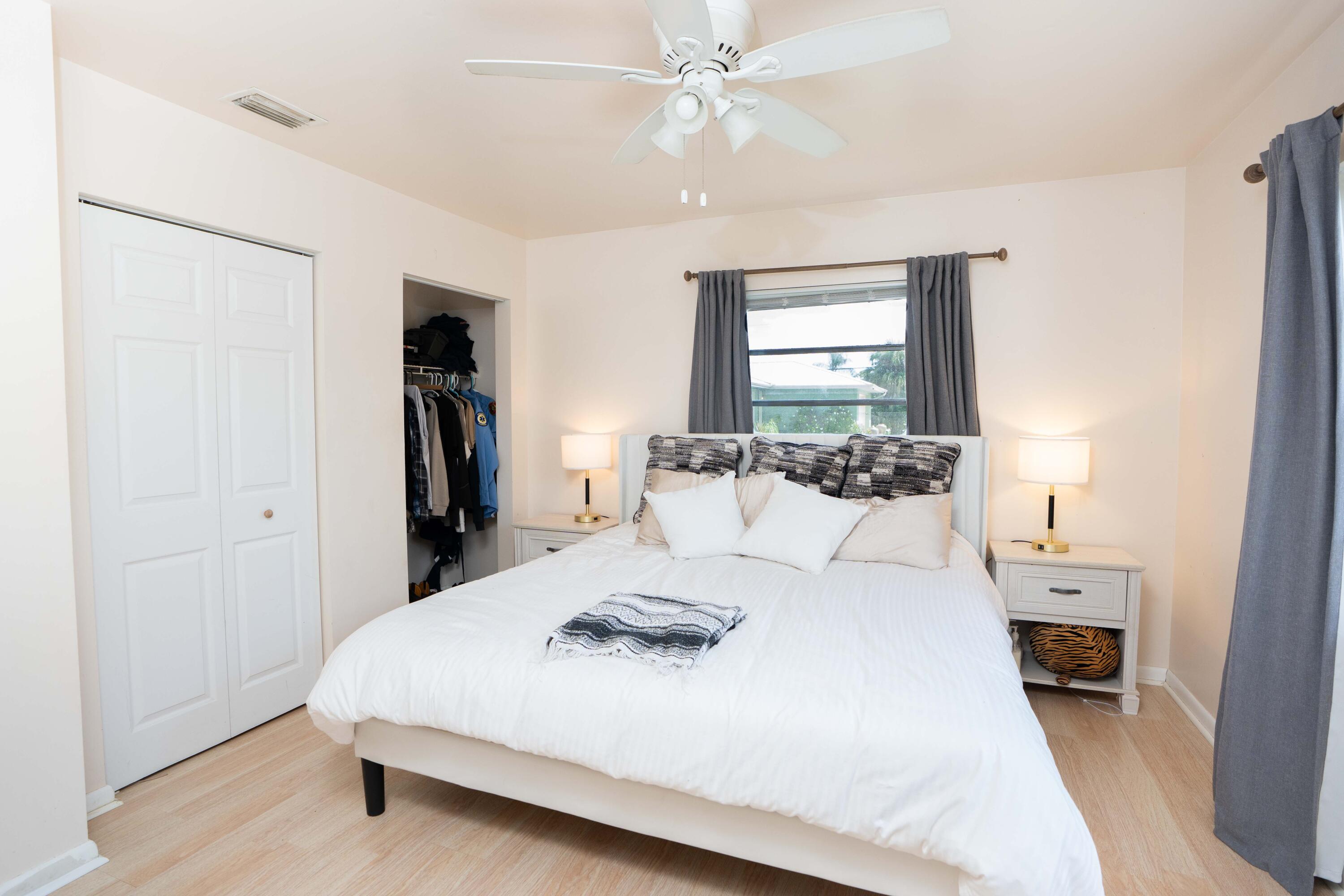 1849 Northwest Pine Tree Way Stuart, FL 34994 - Photo 13 of 29 a large white bed in a white room