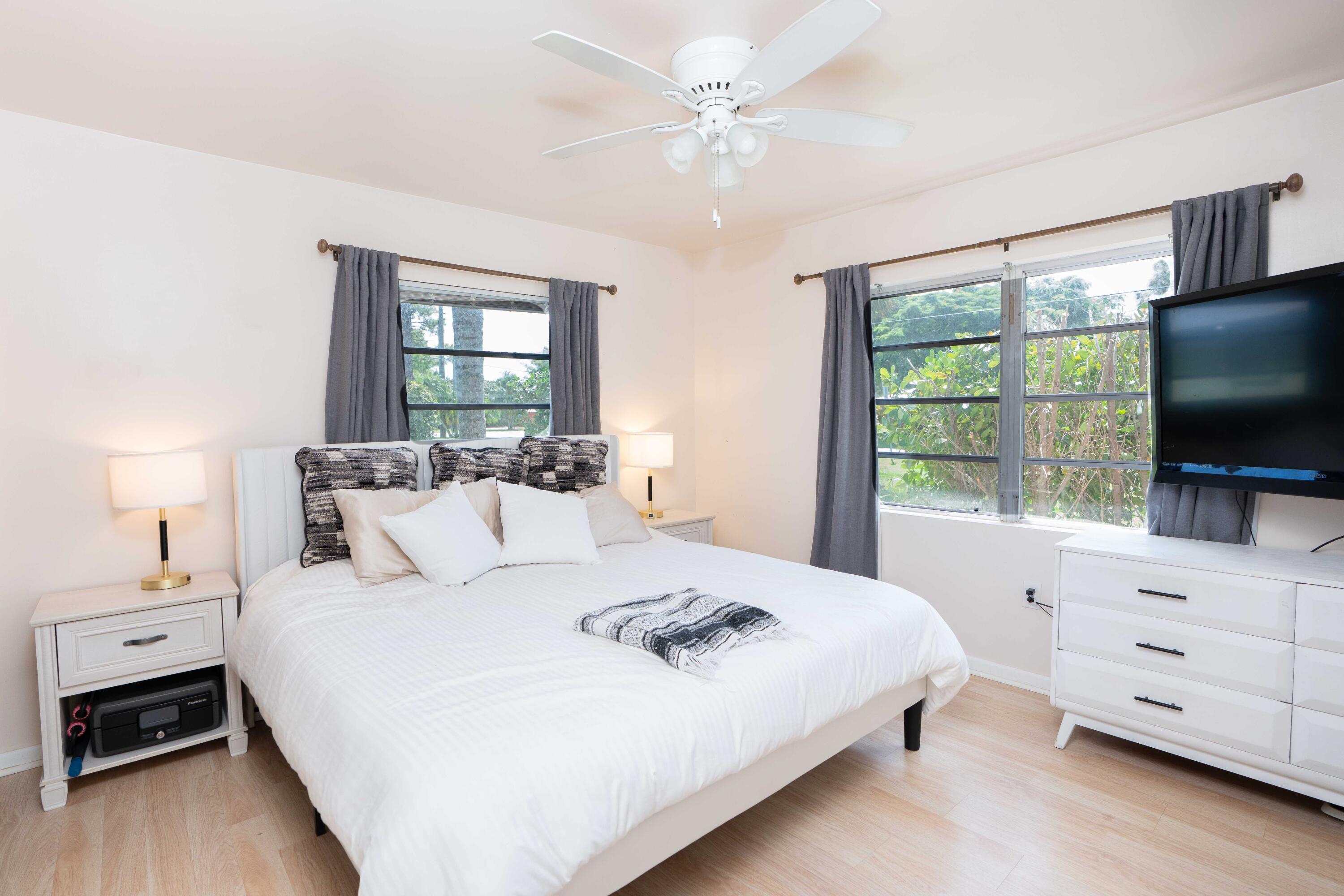 1849 Northwest Pine Tree Way Stuart, FL 34994 - Photo 14 of 29 a bedroom with a bed and a flat screen tv