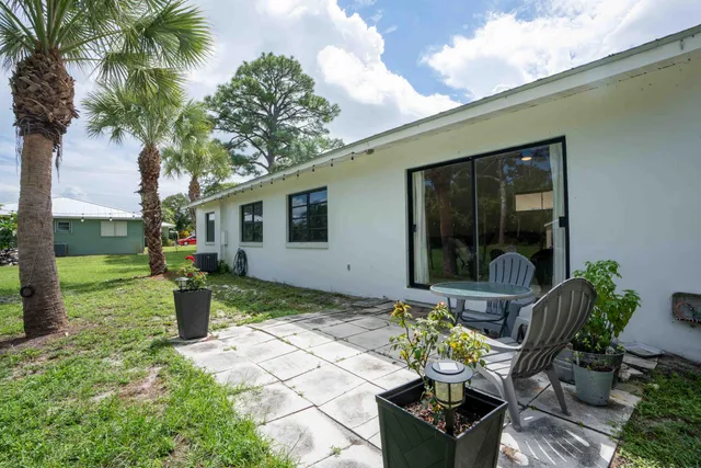 a view of a house with backyard sitting area and garden