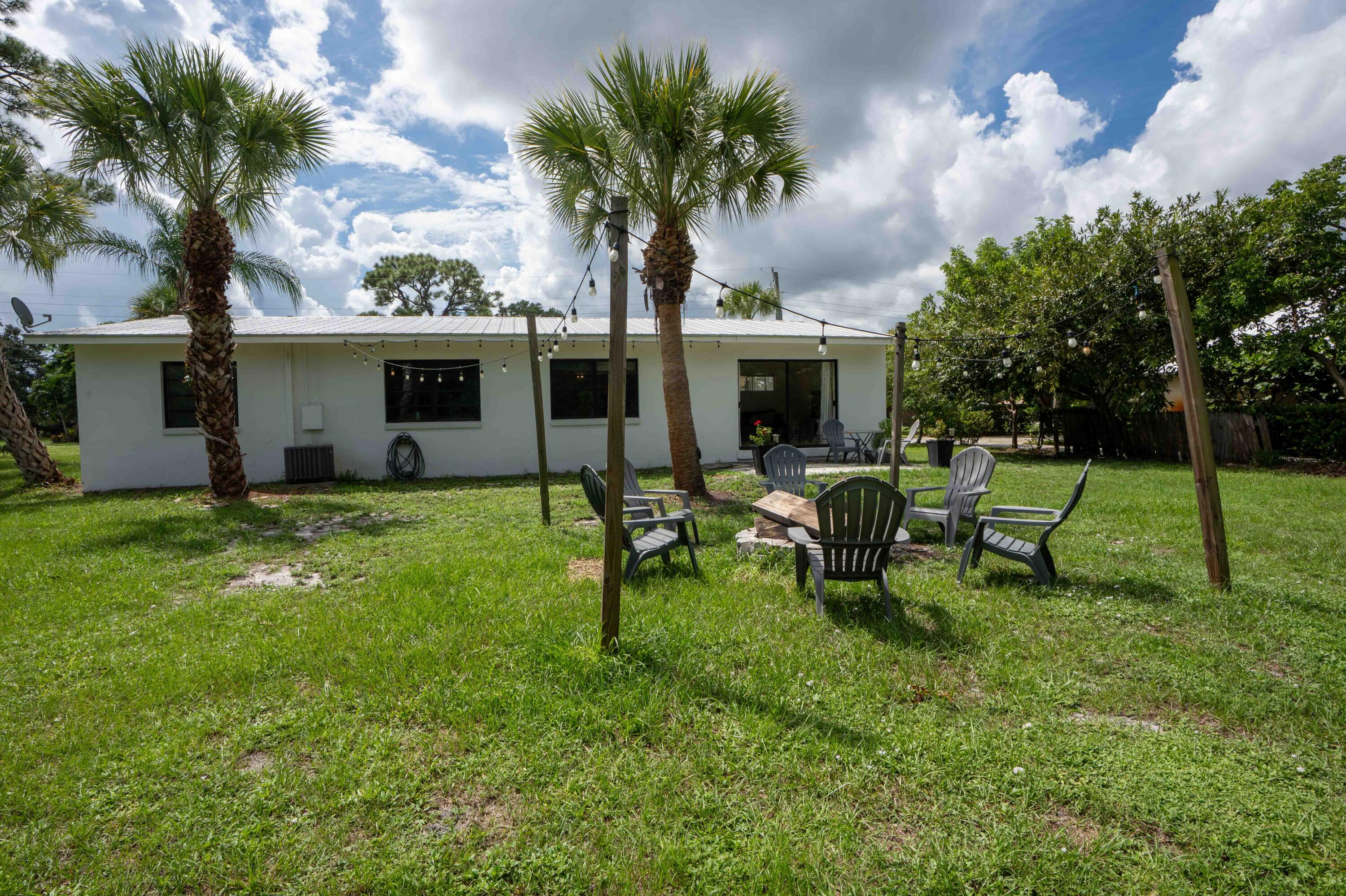 1849 Northwest Pine Tree Way Stuart, FL 34994 - Photo 19 of 29 a view of a house with backyard sitting area and garden